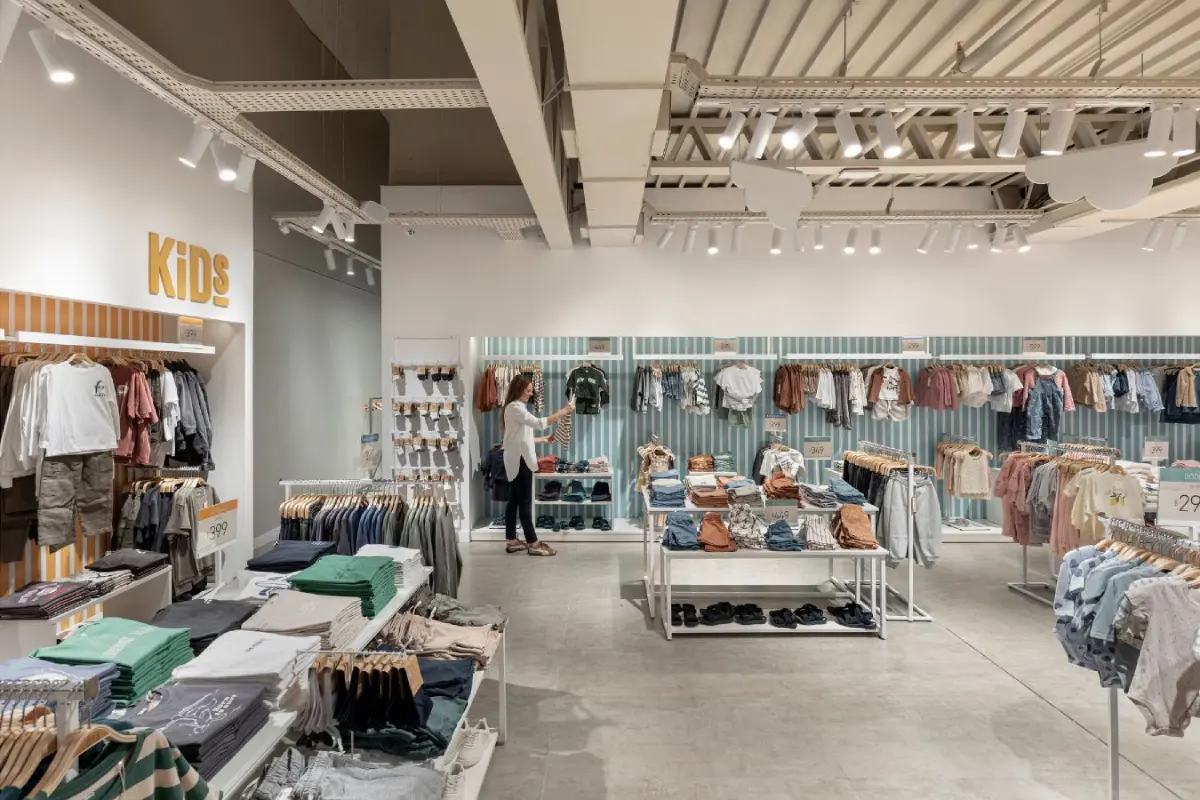 BAS Retail Store - Children's clothing section with organized aisle layout and wood flooring - Contract Workplaces.webp